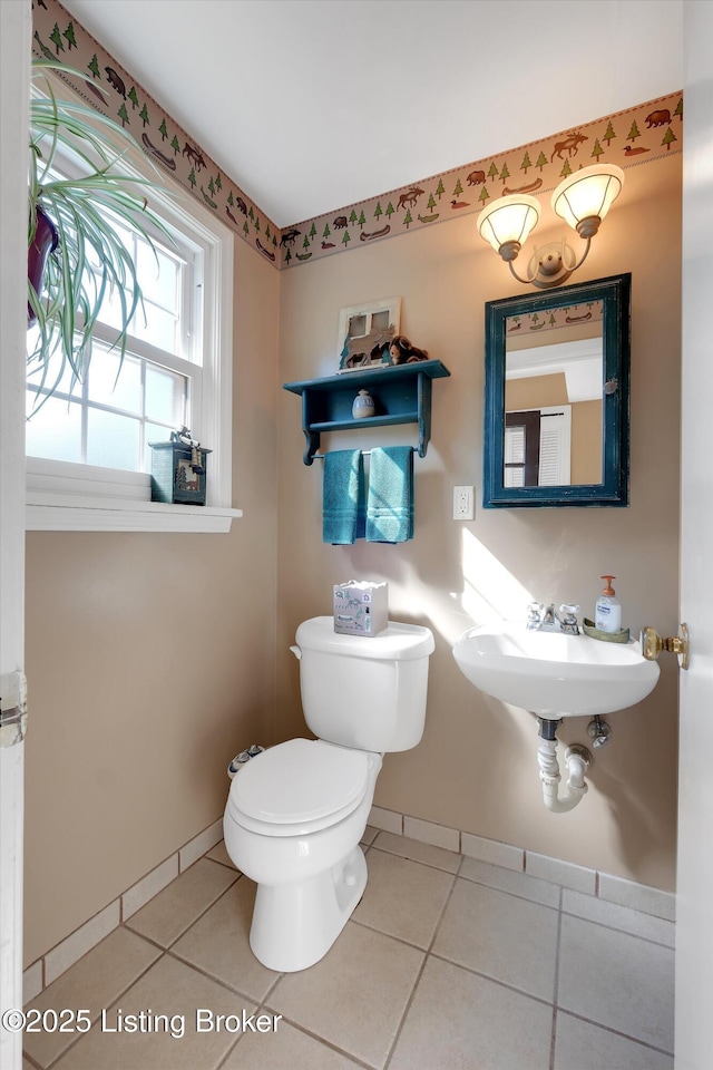 bathroom featuring toilet, tile patterned flooring, a sink, and baseboards