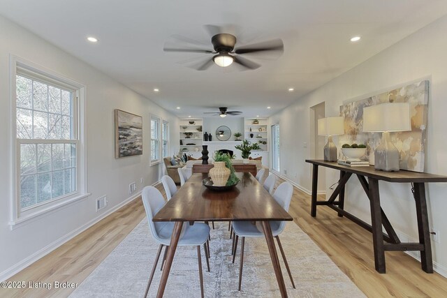 dining room featuring a wealth of natural light, a ceiling fan, and light wood-type flooring