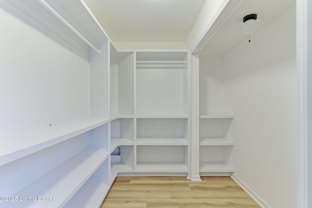 walk in closet with wood finished floors