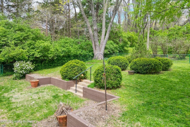 view of community featuring a lawn and fence