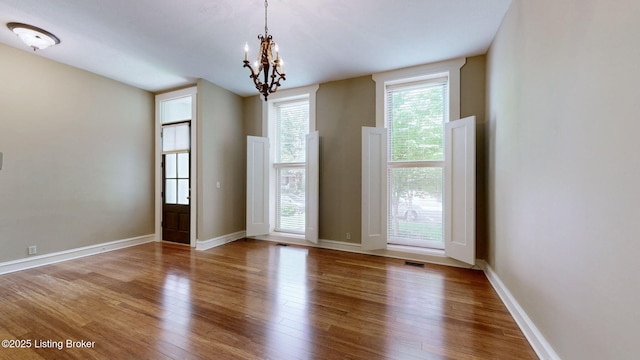 1031 S 7th St, Louisville, KY 40203 - unfurnished room with wood finished floors, a chandelier, and baseboards