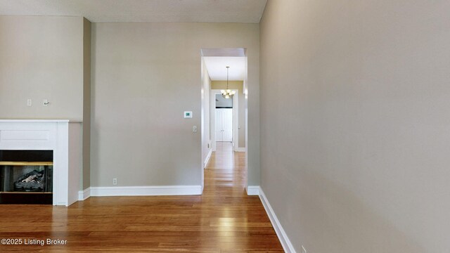 1031 S 7th St, Louisville, KY 40203 - hallway featuring wood finished floors, a chandelier, and baseboards