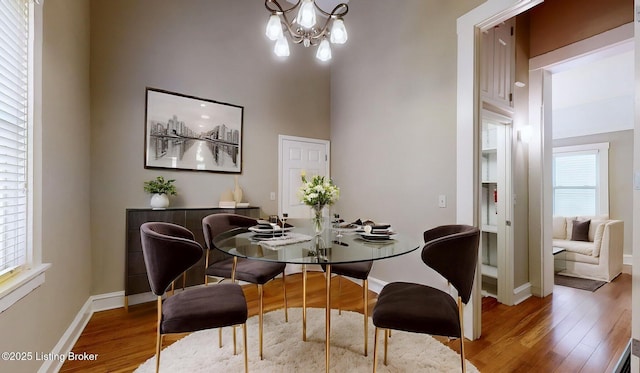 1031 S 7th St, Louisville, KY 40203 - dining area with wood finished floors, baseboards, and a chandelier