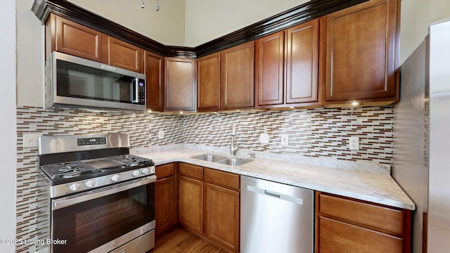 1031 S 7th St, Louisville, KY 40203 - kitchen featuring appliances with stainless steel finishes, a sink, decorative backsplash, light stone counters, and light wood-style floors