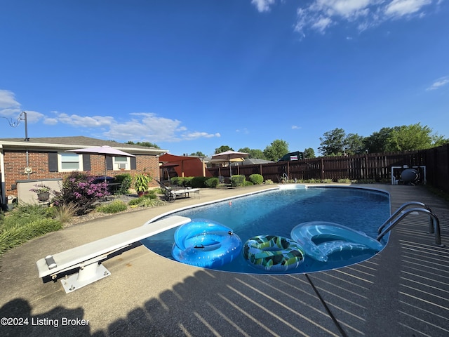 view of pool featuring a fenced in pool, fence private yard, a diving board, and a patio