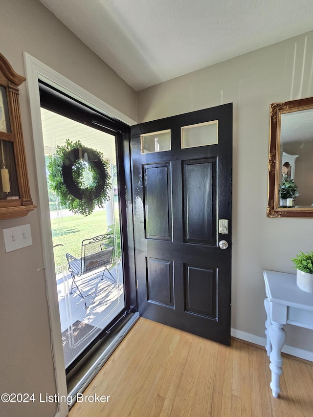 entryway with baseboards and light wood finished floors
