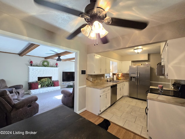 kitchen with a ceiling fan, open floor plan, stainless steel appliances, and a sink