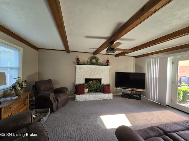 living room with beamed ceiling, a fireplace, carpet floors, and a ceiling fan