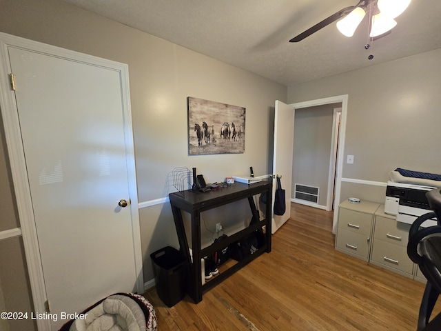 office area featuring visible vents, baseboards, a ceiling fan, and wood finished floors