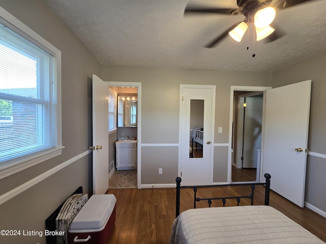 bedroom with wood finished floors, a sink, and multiple windows