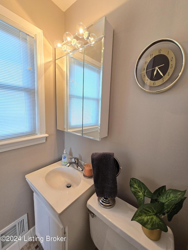 bathroom featuring an inviting chandelier, a healthy amount of sunlight, vanity, and visible vents