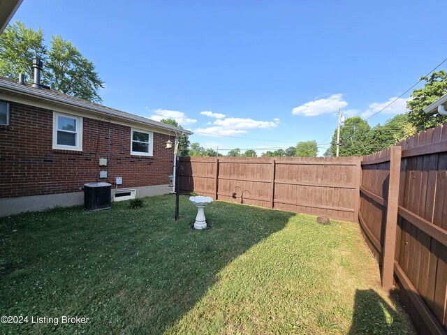 view of yard with a fenced backyard and central air condition unit