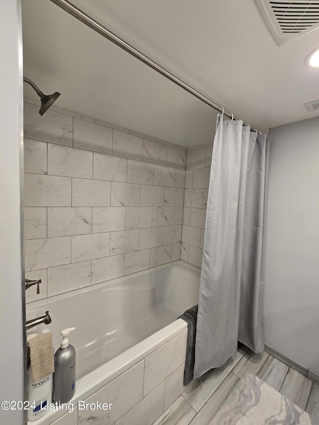 bathroom featuring shower / bath combination with curtain and visible vents