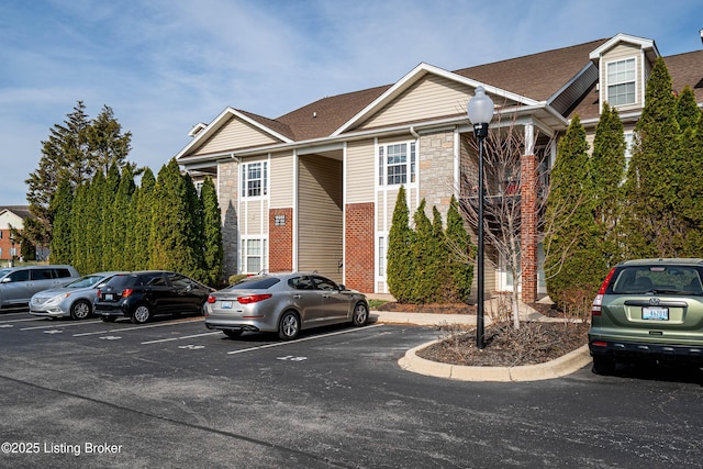 10202 Deer Vista Dr Unit 202, Louisville, KY 40291 - view of front facade featuring uncovered parking, stone siding, and a shingled roof