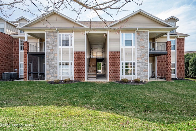 10202 Deer Vista Dr Unit 202, Louisville, KY 40291 - rear view of property featuring stone siding, a lawn, brick siding, and central AC unit
