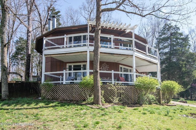 back of property featuring a lawn and a balcony