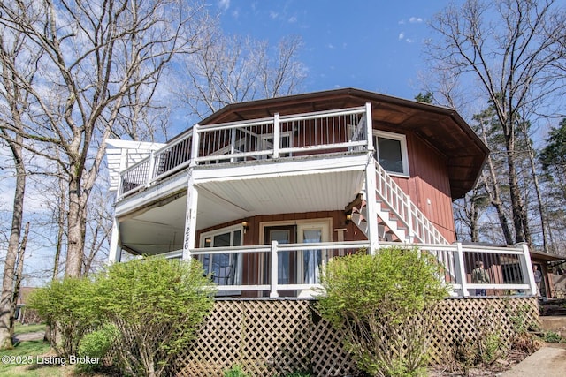 view of side of home with stairs and covered porch