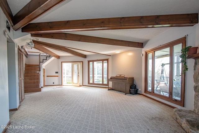 unfurnished living room featuring light colored carpet, baseboards, and beam ceiling