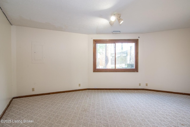 unfurnished room featuring light carpet, electric panel, visible vents, and baseboards