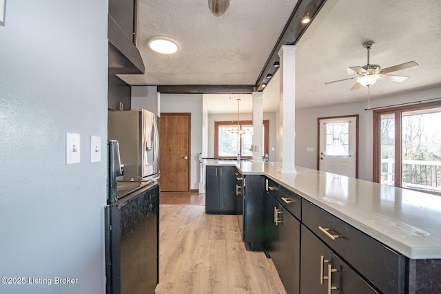kitchen featuring stainless steel fridge with ice dispenser, a healthy amount of sunlight, a textured ceiling, and light wood-type flooring