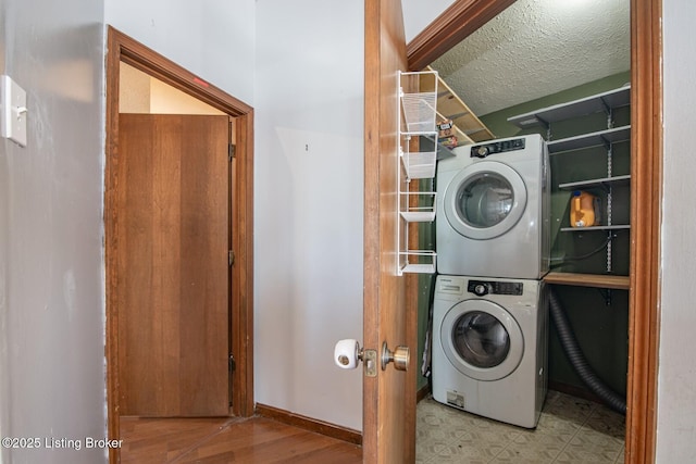 laundry room with stacked washing maching and dryer, baseboards, and laundry area