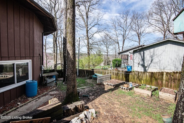 view of yard featuring fence and a vegetable garden