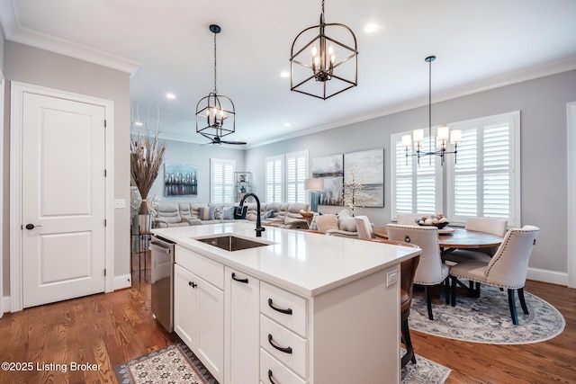kitchen featuring crown molding, a sink, dishwasher, an inviting chandelier, and pendant lighting