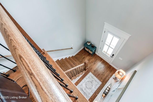 staircase with lofted ceiling and wood finished floors