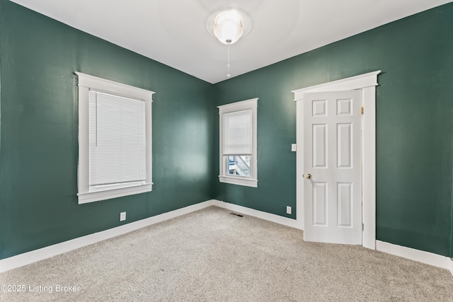 carpeted empty room featuring visible vents and baseboards