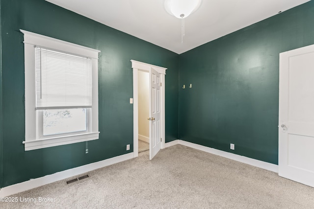 unfurnished room featuring baseboards, carpet flooring, and visible vents