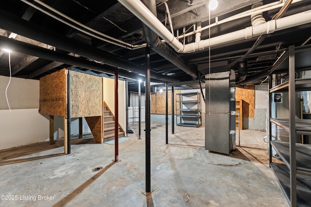 unfinished basement with heating unit and stairway