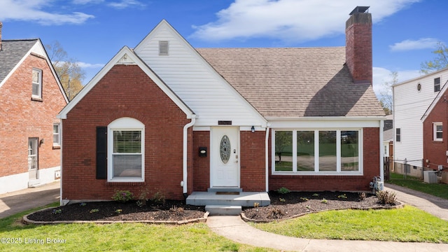109 Ridgeway Ave, Louisville, KY 40207 - tudor house with brick siding, a chimney, cooling unit, and roof with shingles
