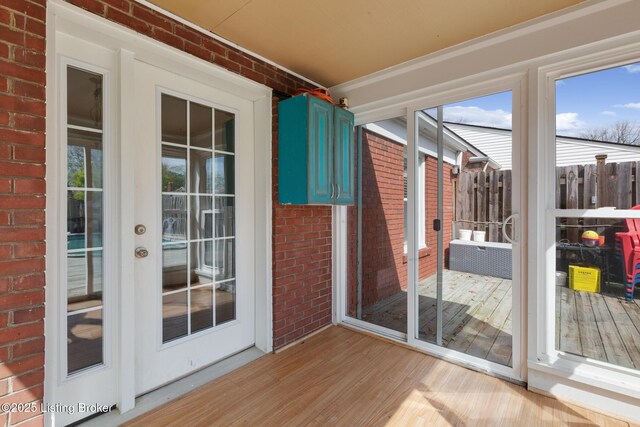109 Ridgeway Ave, Louisville, KY 40207 - unfurnished sunroom featuring wood finished floors, french doors, brick wall, and a wooden deck