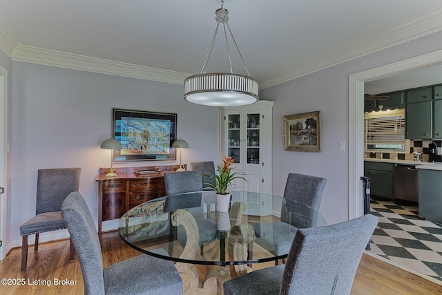 dining area featuring crown molding and light wood finished floors