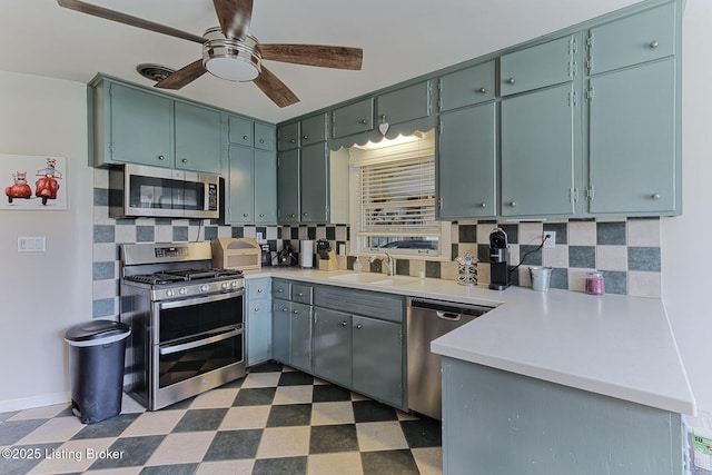 kitchen featuring tasteful backsplash, dark floors, appliances with stainless steel finishes, and a ceiling fan