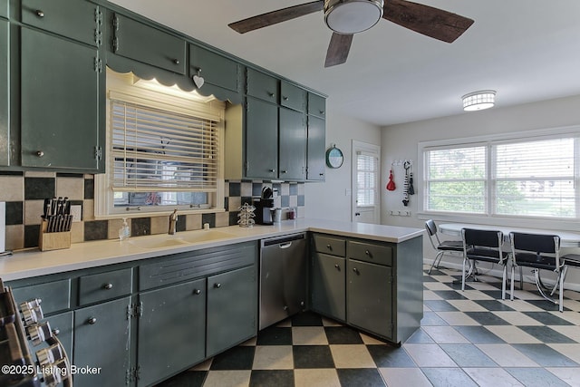 kitchen with dark floors, dishwasher, a ceiling fan, a sink, and a peninsula