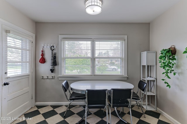 dining space featuring light floors and baseboards