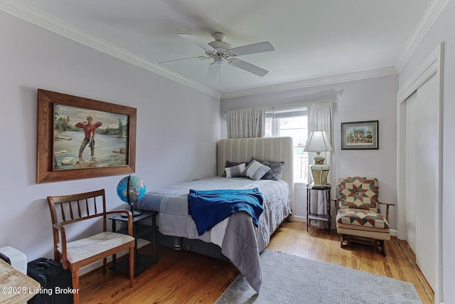 bedroom with light wood finished floors, a ceiling fan, and ornamental molding