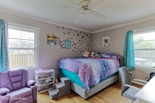 bedroom with ornamental molding, light wood finished floors, and multiple windows
