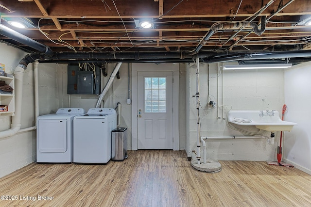 below grade area with separate washer and dryer, wood finished floors, and electric panel