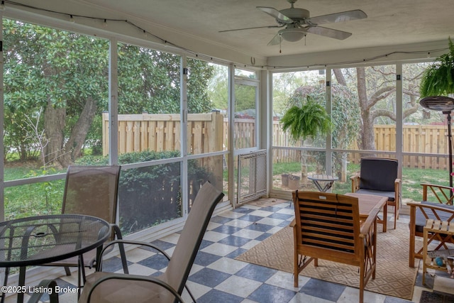 sunroom / solarium featuring a ceiling fan and outdoor dining area