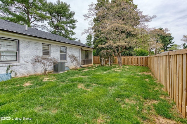 view of yard featuring a sunroom, a fenced backyard, and central AC unit