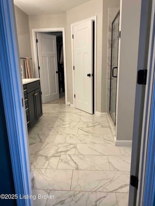 hall with baseboards and marble finish floor