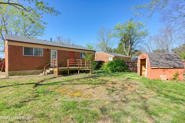 4311 Kurtz Ave, Louisville, KY 40229 - rear view of house featuring a storage unit, brick siding, a yard, and a deck