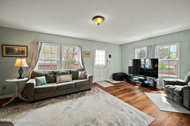 living room featuring a decorative wall, a healthy amount of sunlight, and wood finished floors