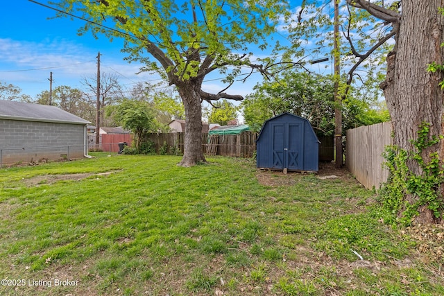 view of yard with a storage shed, an outbuilding, and a fenced backyard