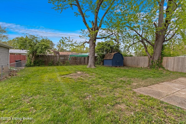 view of yard featuring an outdoor structure, a fenced backyard, and a shed