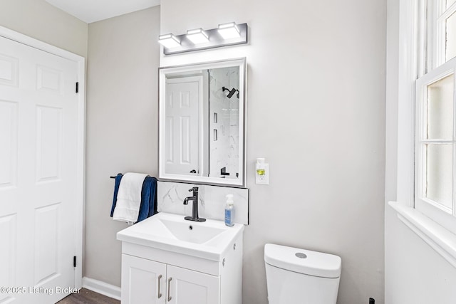 bathroom featuring vanity, a shower, and toilet