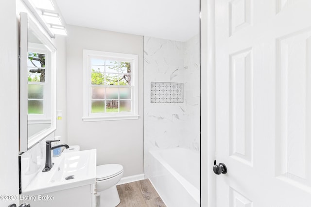 bathroom with toilet, baseboards, wood finished floors, and vanity