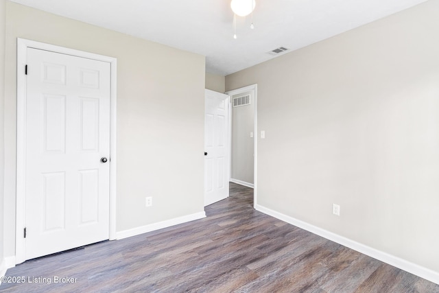 unfurnished bedroom featuring visible vents, baseboards, and wood finished floors